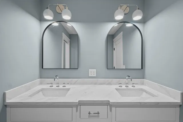 a bathroom with double vanity sinks and a mirror