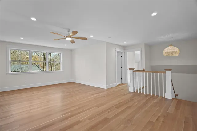 a view of an empty room with a window and wooden floor