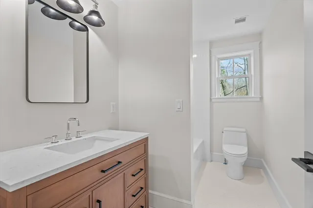 a bathroom with a toilet sink and mirror