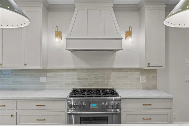 a kitchen with white cabinets and a stove