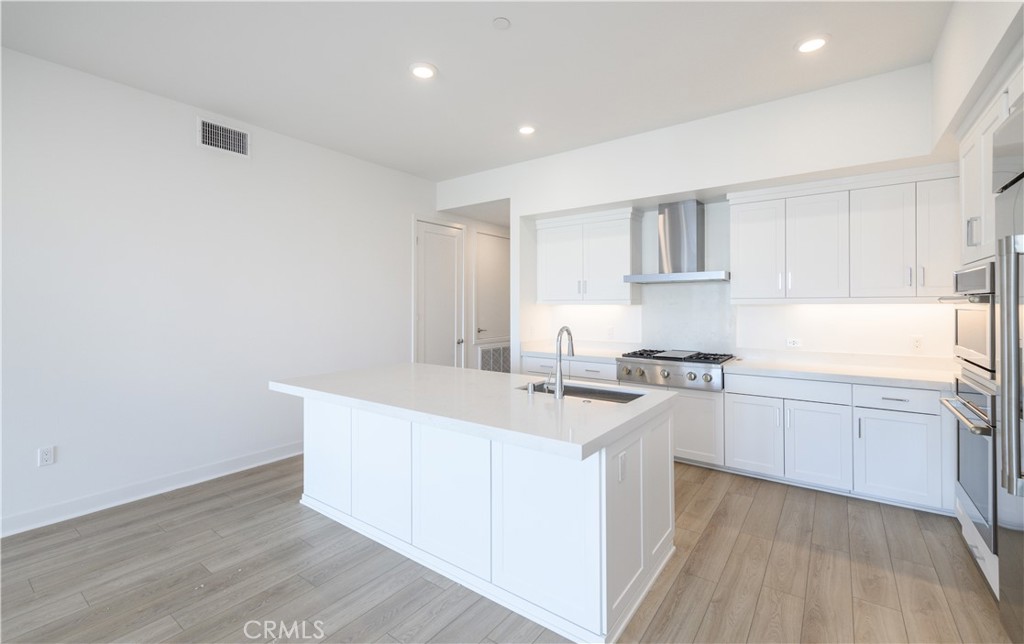 3608 Rivington Irvine, CA 92612 - Photo 18 of 74 a kitchen with sink cabinets and wooden floor