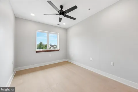 an empty room with a window and a ceiling fan