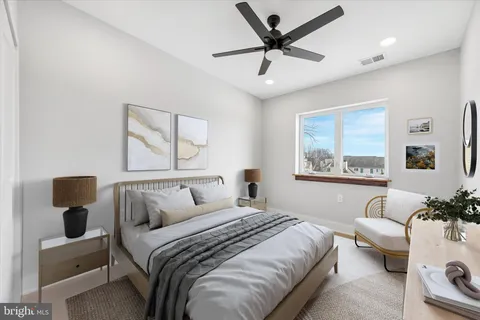 a bedroom with a large bed couch and a window