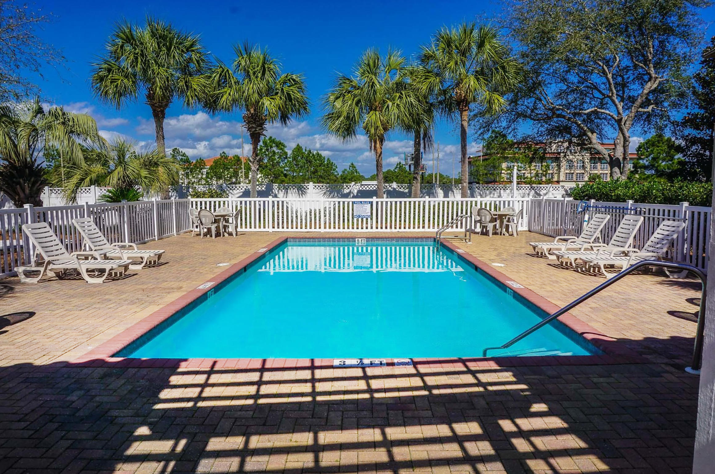 55 St Simon Circle Miramar Beach, FL 32550 - Photo 44 of 45 a view of a swimming pool with a patio and wooden furniture