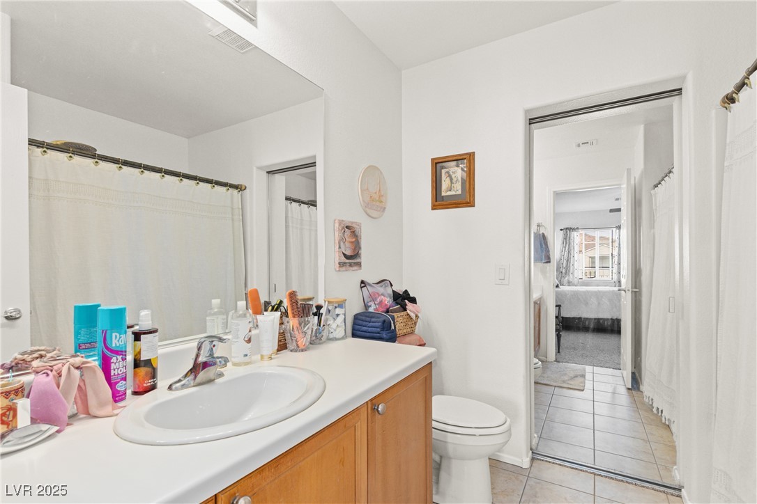 9105 Silk Threads Avenue Las Vegas, NV 89149 - Photo 15 of 25 Ensuite bathroom featuring vanity, light tile patterned floors, and a shower/tub combo