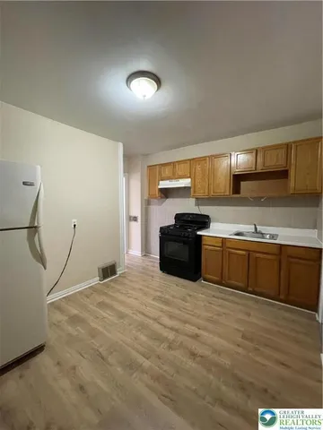 a kitchen with stainless steel appliances kitchen island granite countertop a stove a sink and a microwave