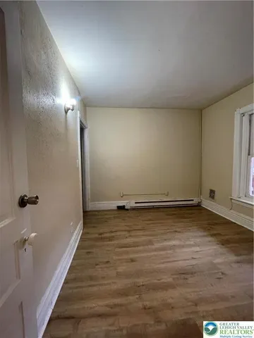 a view of a room with wooden floor