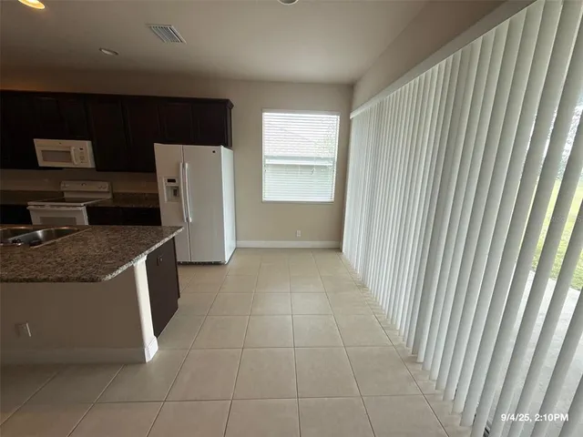 a view of a kitchen with refrigerator and microwave