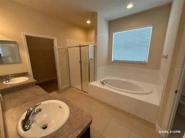 a bathroom with a tub sink and mirror