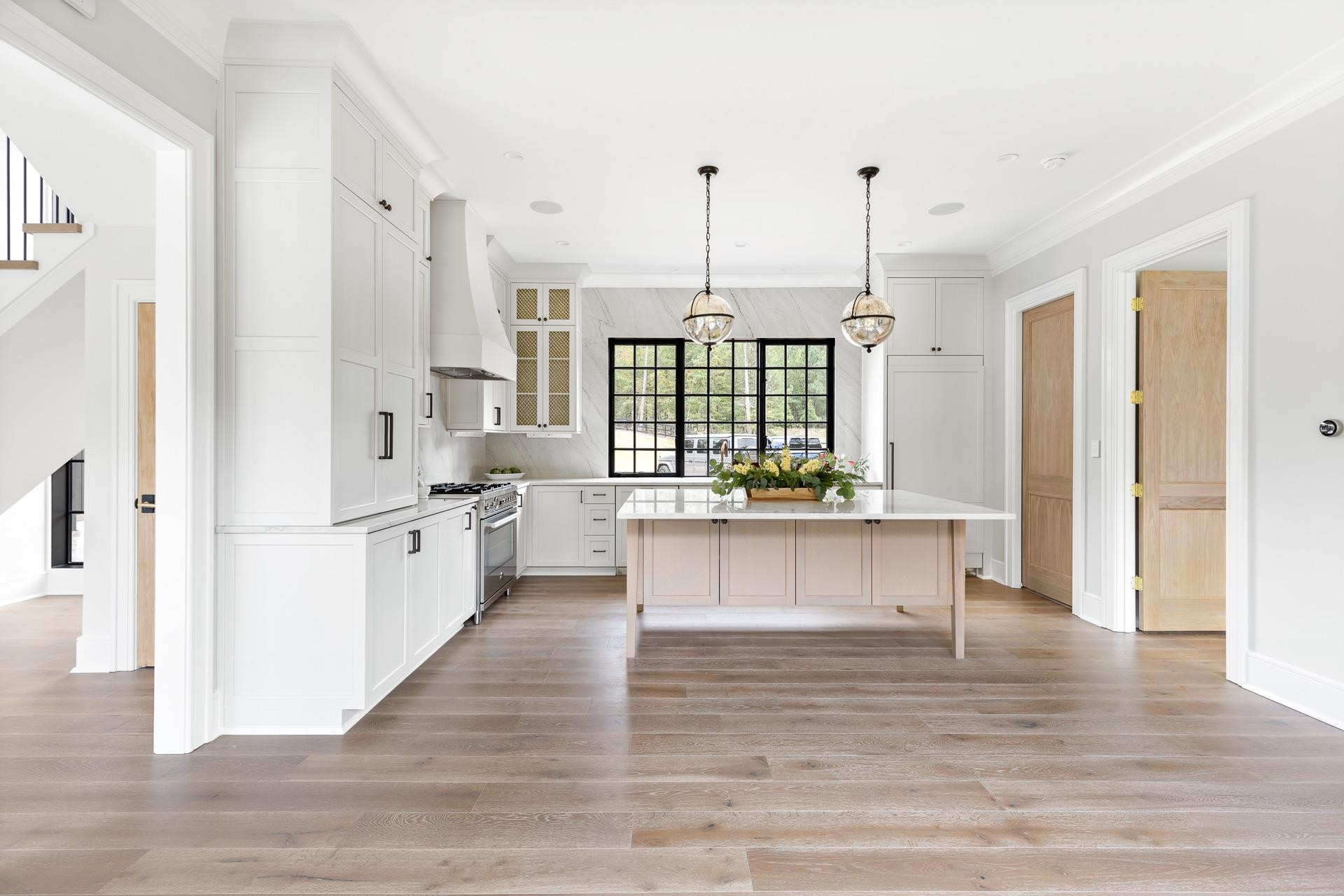 155 Settlement Drive Apex, NC 27523 - Photo 25 of 65 a kitchen with stainless steel appliances a large counter top a stove a refrigerator and white cabinets