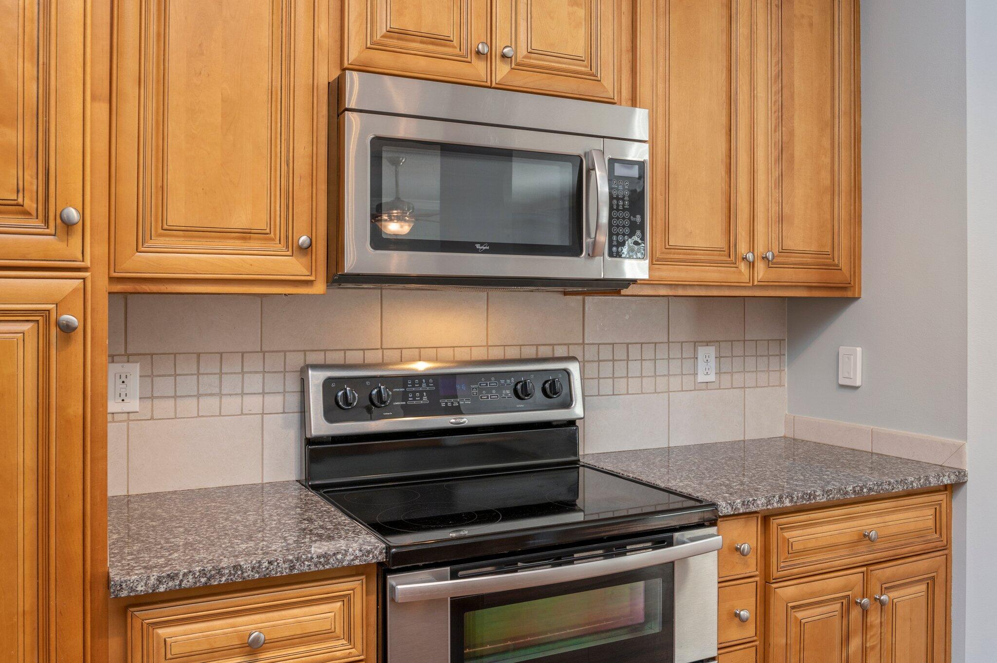 4623 Hermosa Road Crestview, FL 32539 - Photo 15 of 41 a kitchen with granite countertop a stove top oven microwave and cabinets