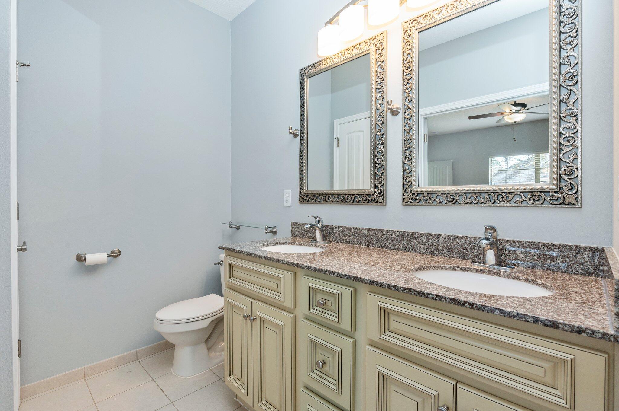 4623 Hermosa Road Crestview, FL 32539 - Photo 23 of 41 a bathroom with a granite countertop toilet sink and mirror