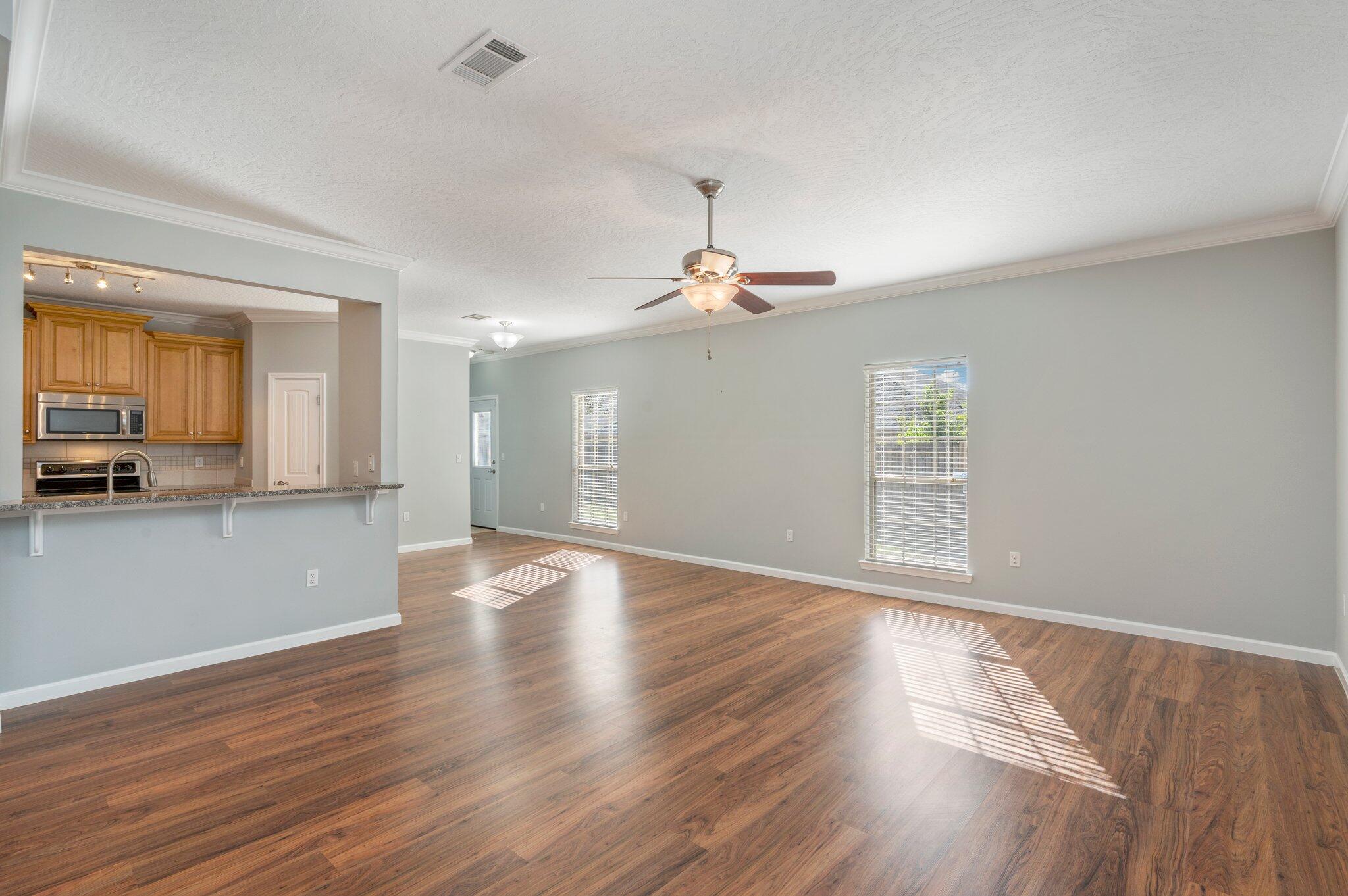 4623 Hermosa Road Crestview, FL 32539 - Photo 6 of 41 a view of an empty room with wooden floor and a window