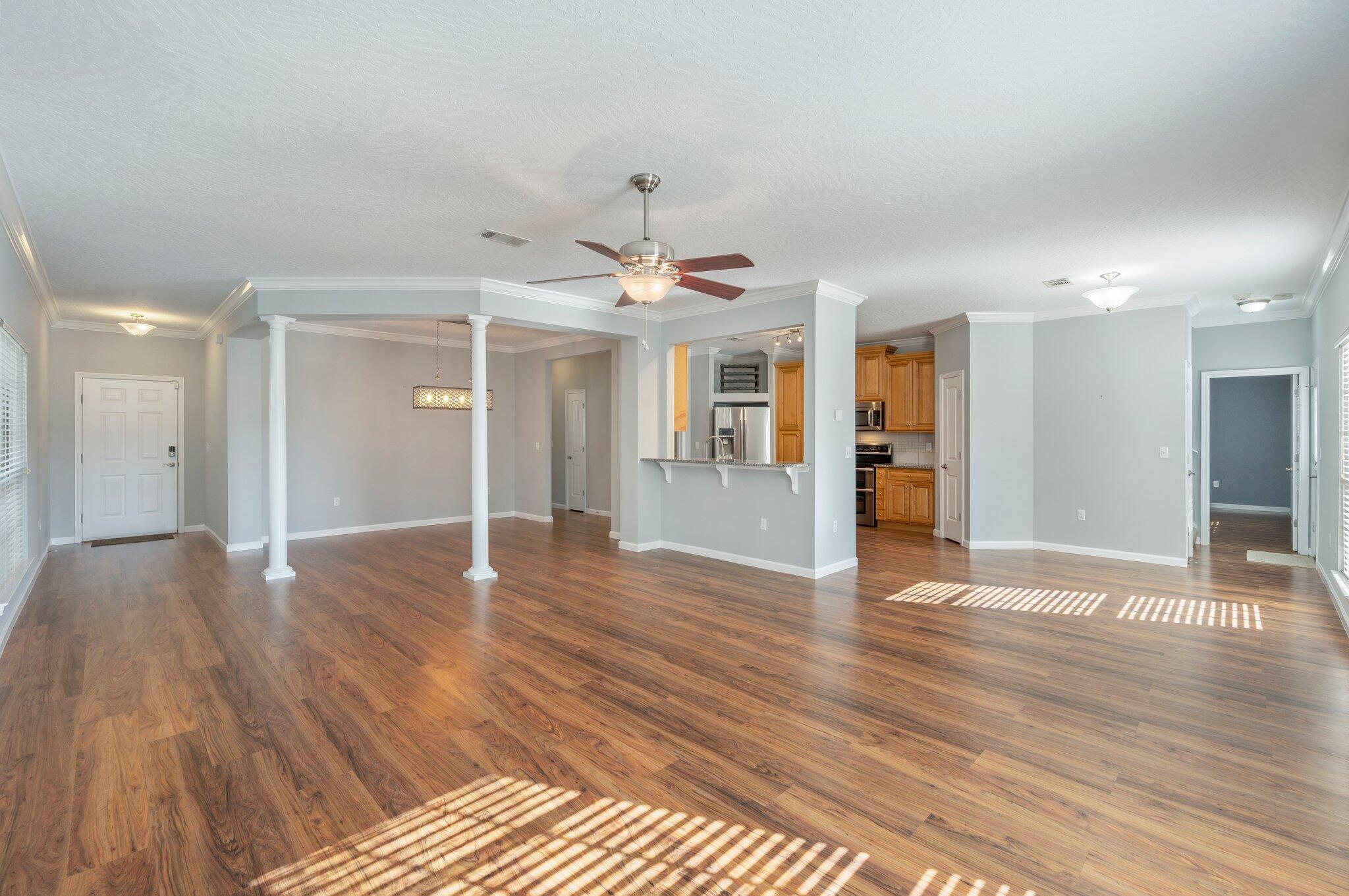 4623 Hermosa Road Crestview, FL 32539 - Photo 7 of 41 a view of an empty room with wooden floor and a kitchen