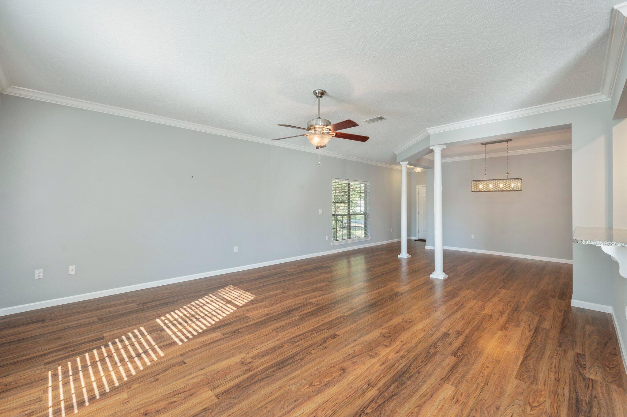 4623 Hermosa Road Crestview, FL 32539 - Photo 8 of 41 a view of an empty room with wooden floor and a window