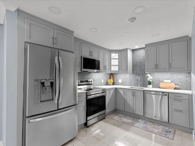 a kitchen with white cabinets and stainless steel appliances