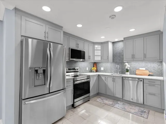 a kitchen with stainless steel appliances granite countertop a refrigerator sink and stove