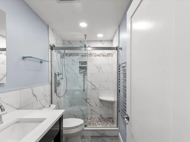 a bathroom with a granite countertop sink toilet and shower