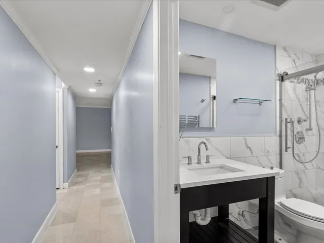 a bathroom with a sink shower and a mirror