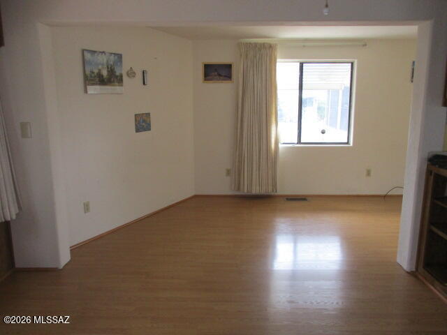 3100 South Kinney Road, Unit 193 Tucson, AZ 85713 - Photo 5 of 35 an empty room with wooden floor and windows