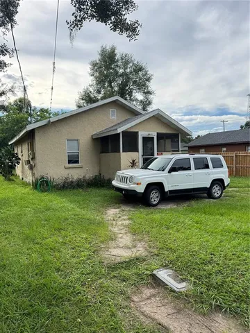 a front view of a house with a garden and trees
