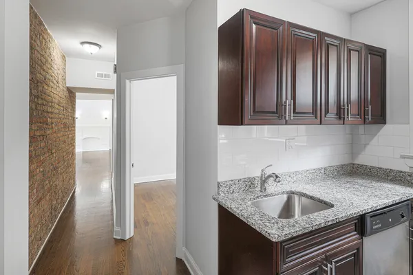 a kitchen with a granite countertop sink and refrigerator