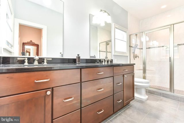 a bathroom with a granite countertop sink mirror vanity and toilet