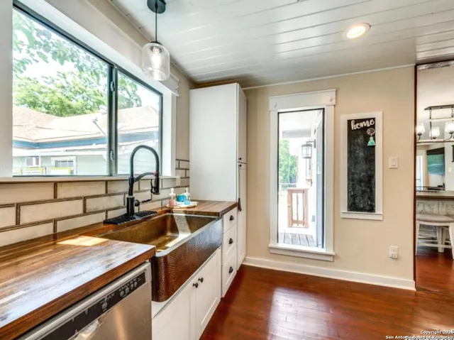 a kitchen that has a sink and a wooden floor