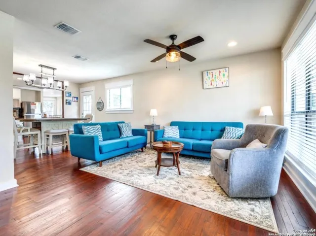 a living room with furniture wooden floor and a window