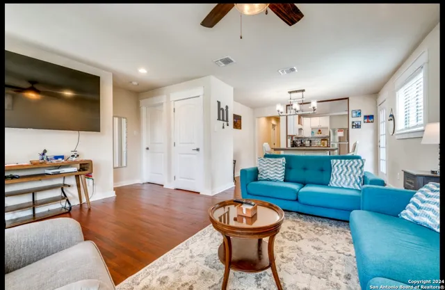 a living room with furniture and a wooden floor