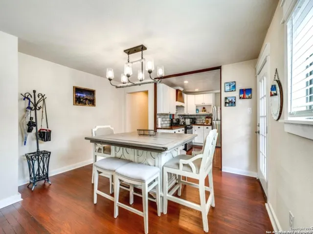 a view of a dining room with furniture a chandelier and wooden floor