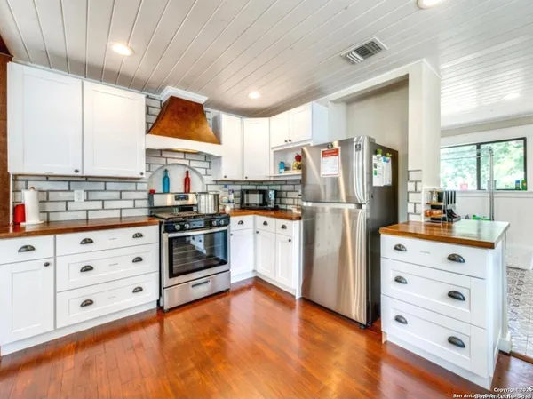 a kitchen with stainless steel appliances a stove a refrigerator and cabinets