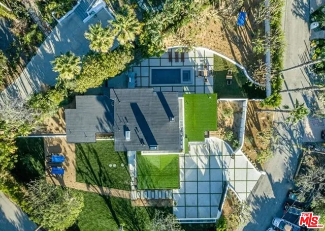 an aerial view of a house with a yard and potted plants