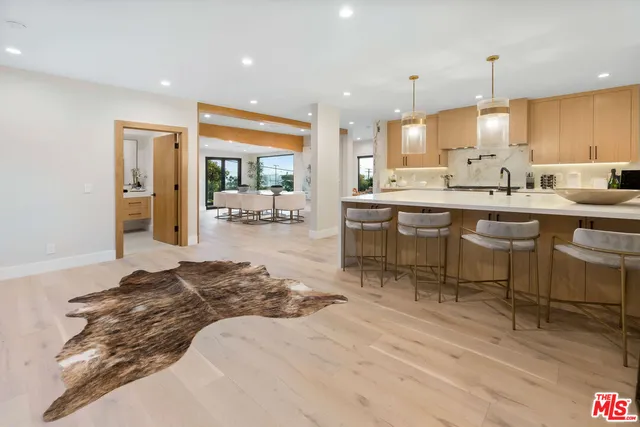 a large kitchen with kitchen island a sink table and chairs