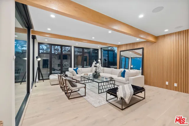 a living room with patio furniture and a large window