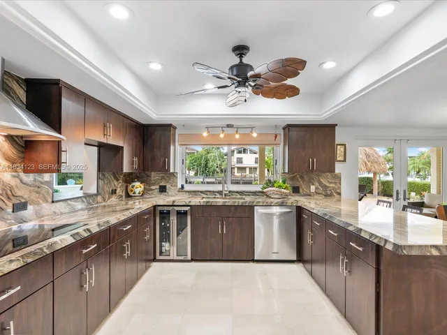 a large kitchen with a large counter space cabinets a sink a window and appliances