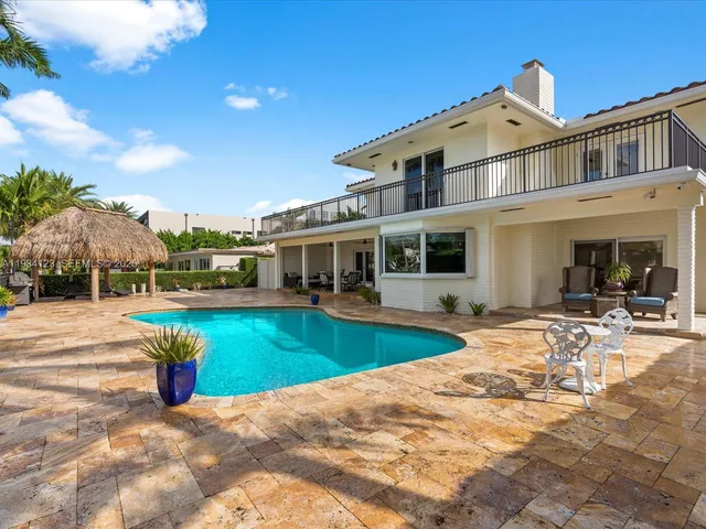 a view of a house with swimming pool and sitting area