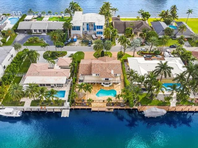an aerial view of residential houses with outdoor space and swimming pool