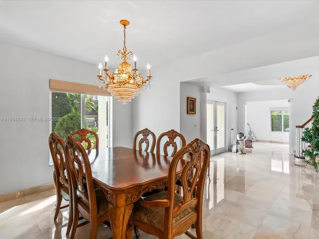a dining room with furniture a chandelier and window