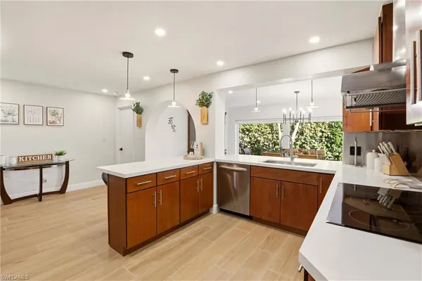 a kitchen with stainless steel appliances granite countertop a sink a stove and a wooden floors