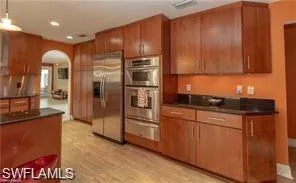 a kitchen with stainless steel appliances granite countertop a refrigerator and a sink