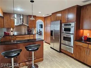 a kitchen with stainless steel appliances granite countertop a refrigerator and a stove top oven