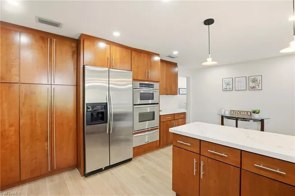 a kitchen with stainless steel appliances a refrigerator and wooden floor