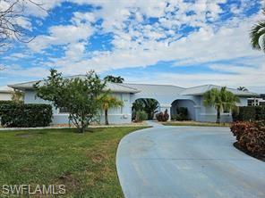 339 Landmark Street Marco Island, FL 34145 - Photo 18 of 18 front view of a house with a yard and potted plants