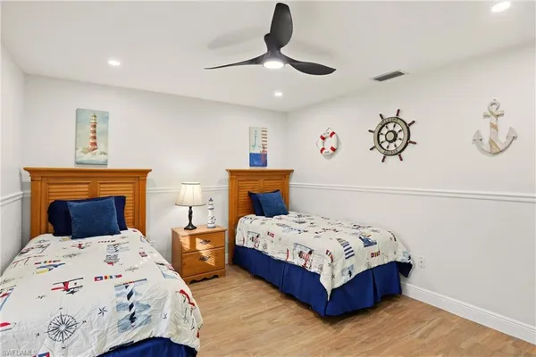 a bedroom with two beds and a chandelier