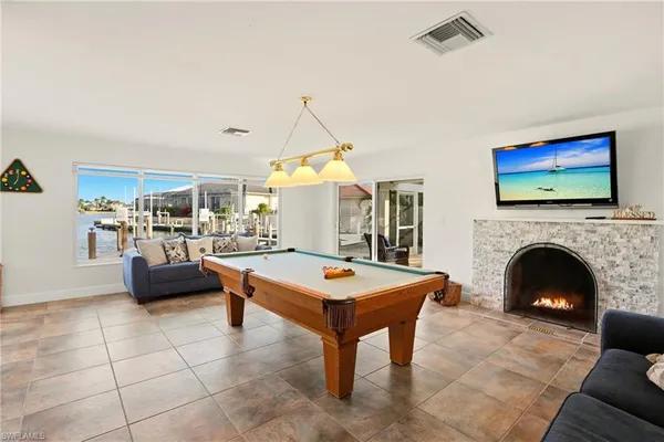a living room with furniture a fireplace and a flat screen tv