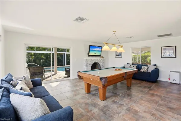 a living room with furniture a fireplace and a floor to ceiling window