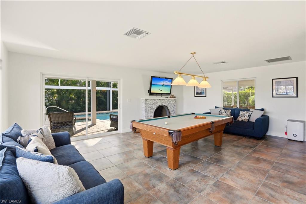 339 Landmark Street Marco Island, FL 34145 - Photo 33 of 49 a living room with furniture a fireplace and a floor to ceiling window