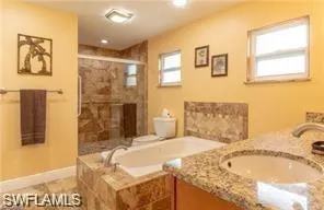 a spacious bedroom with a granite countertop sink and a bathtub