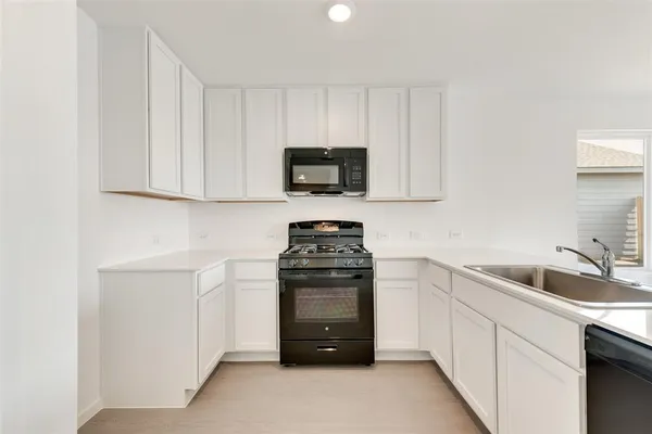 a kitchen with stainless steel appliances a sink stove refrigerator and cabinets
